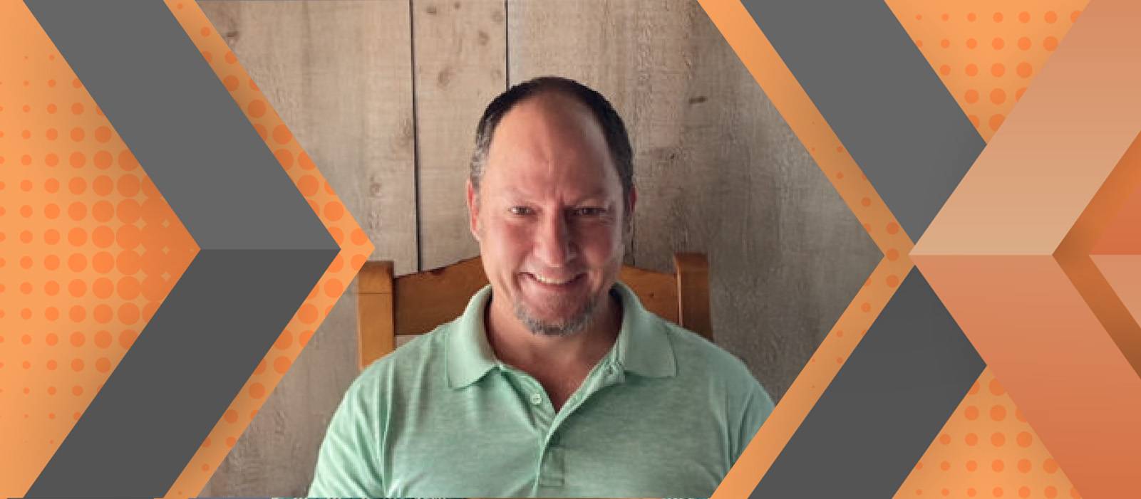 Portrait of Ian Stover framed by an orange and gray geometric background.