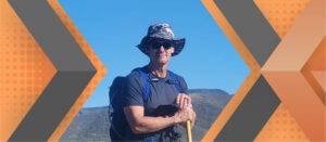 Portrait of Allen Heil framed by an orange and gray geometric background.