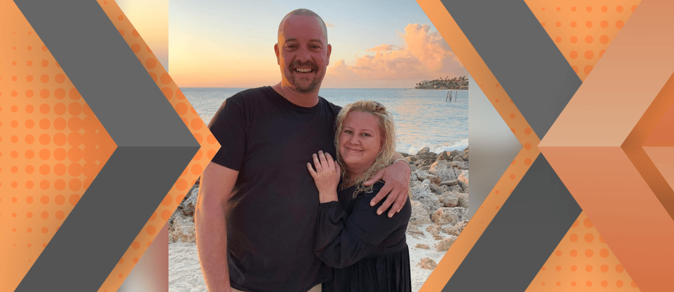 Portrait of Amy Hier and her partner framed by an orange and gray geometric background.