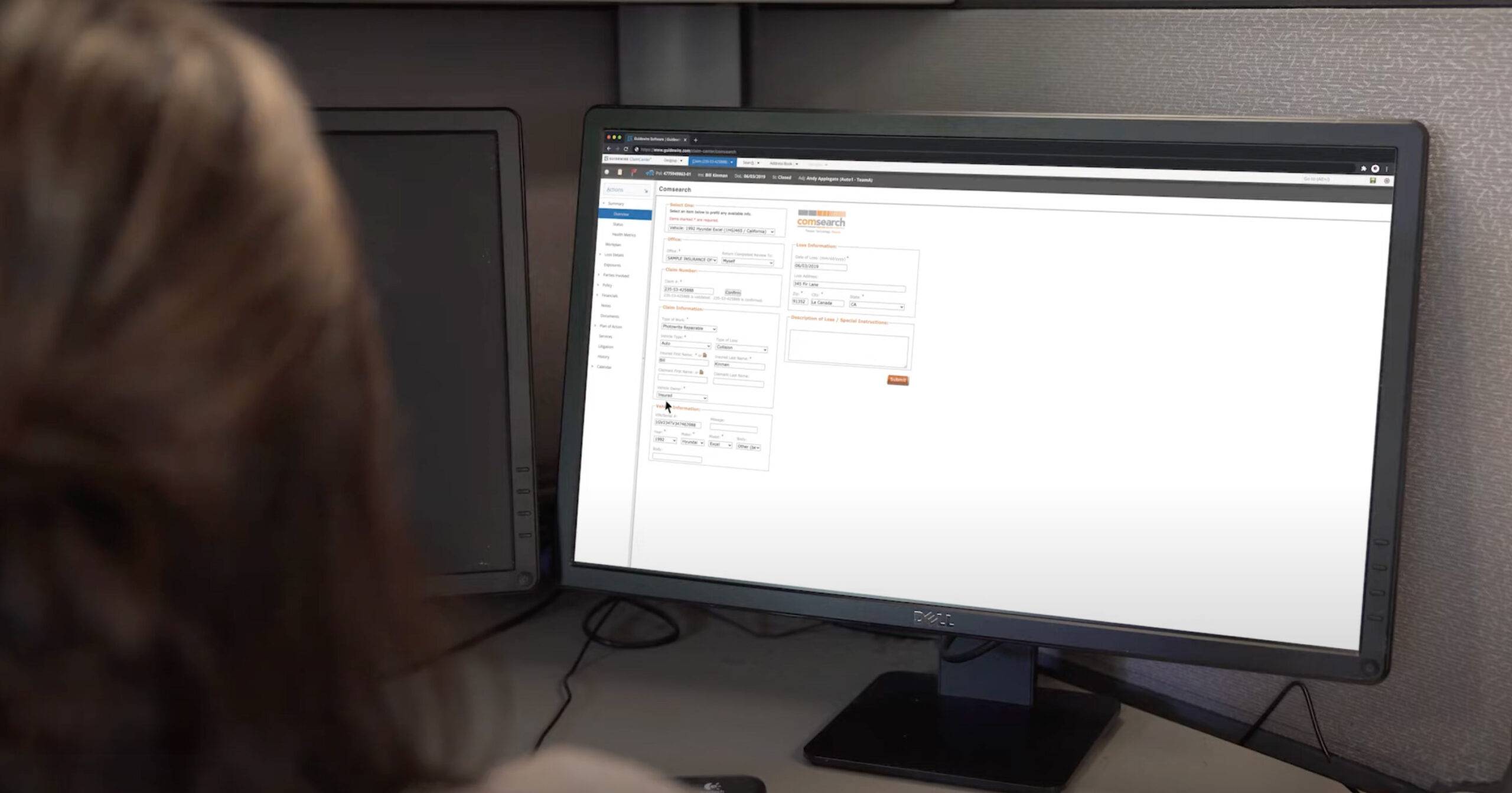 Person working on a desktop computer with a web application form open on the screen.